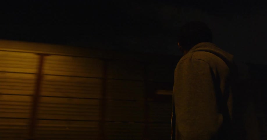 A man looks at a moving train at night