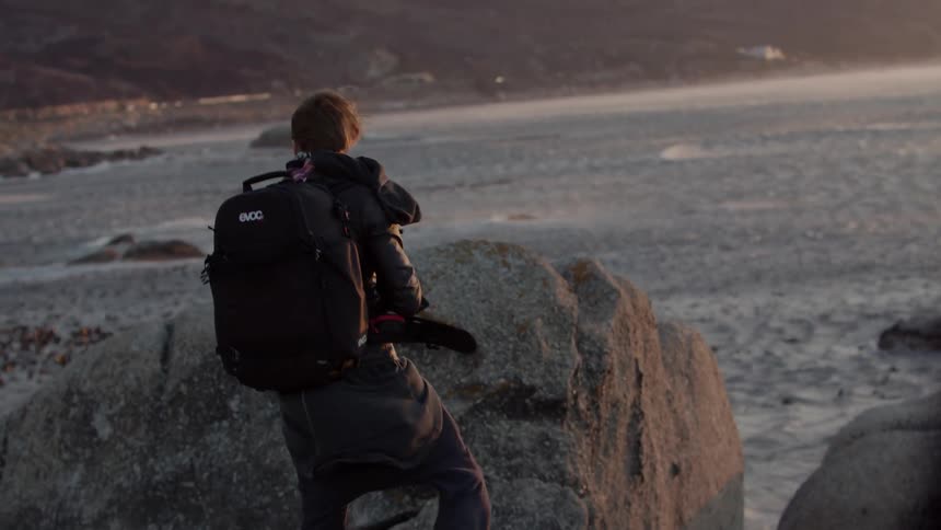 The man is taking photographs near the very windy water