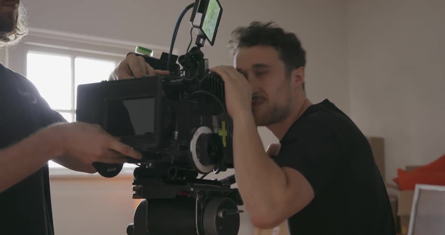 People set up camera equipment in the room