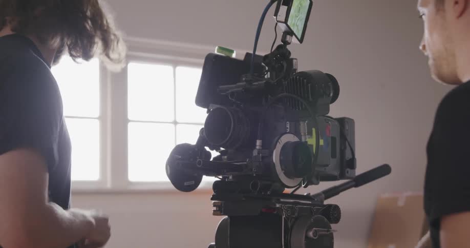 A man adjusts a camera in the room