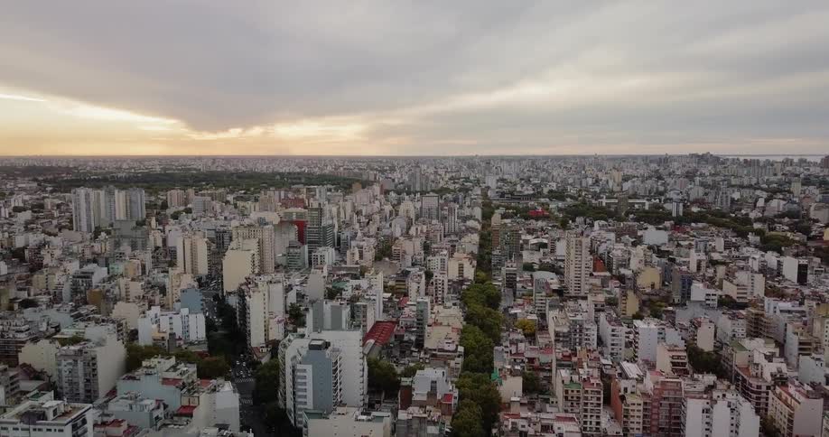 Clouds roll over a large city at sunset