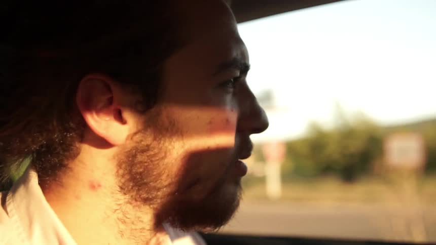 Man rides in a vehicle on a sunny day