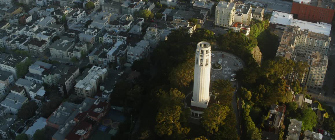A tower stands above the other coastal city buildings
