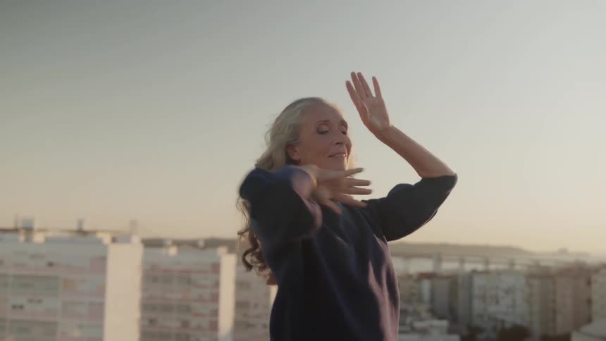Woman dances outside on a sunny day
