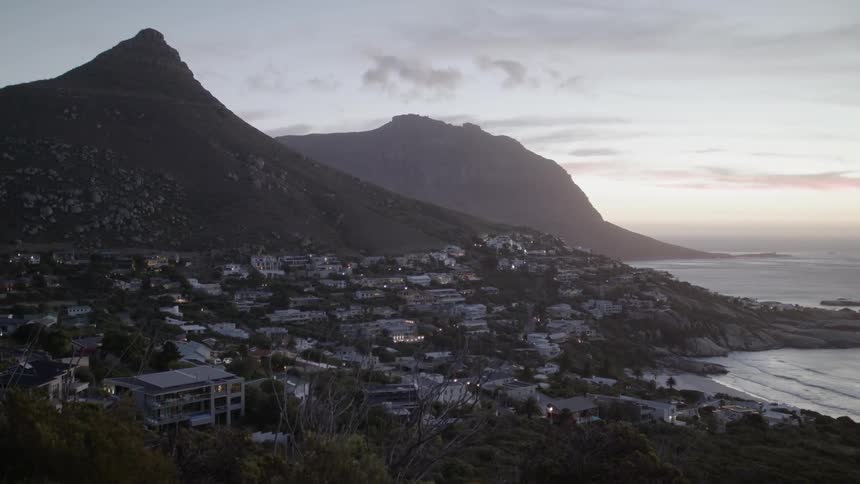 Sun shines over mountains and a city below
