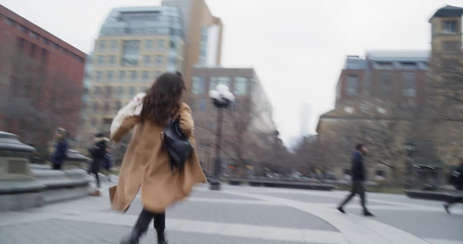 A woman runs through a city square