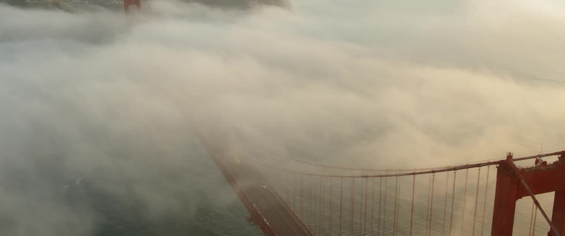 The bridge is covered in heavy fog below