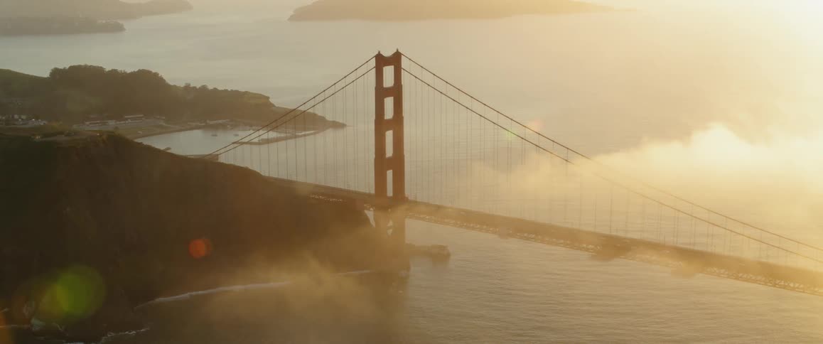 Clouds are drifting over the golden gate bridge at sunset