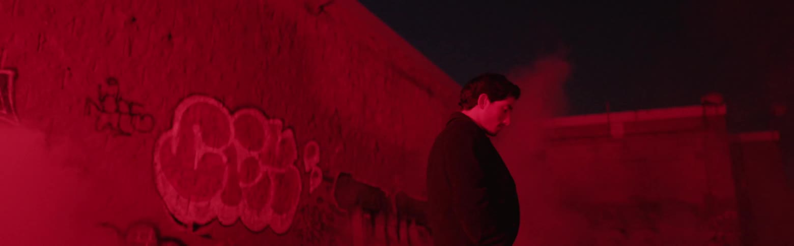 A man walks by a graffiti covered wall