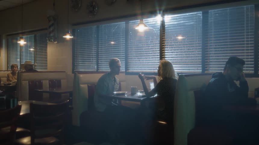 Many people sit at a restaurant at night