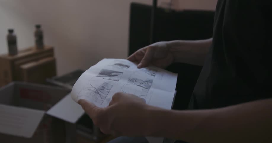 A man looks at drawings on paper