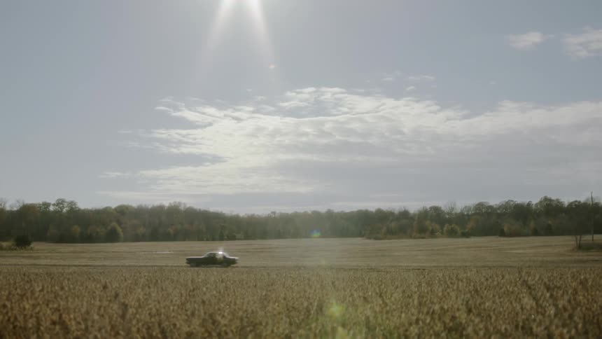 A vehicle travels down a rural road