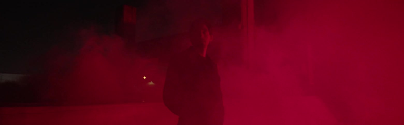 A man stands in red haze