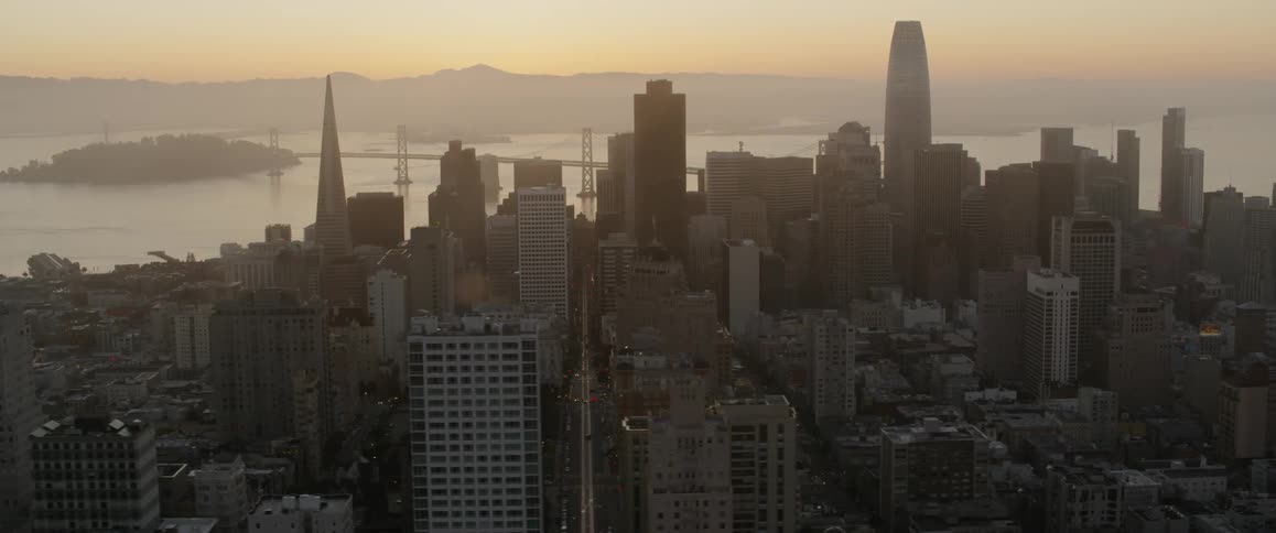 Sun shines down on a large city next to the water
