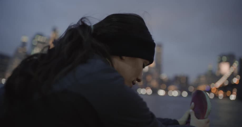 A woman stretches before her run near the water