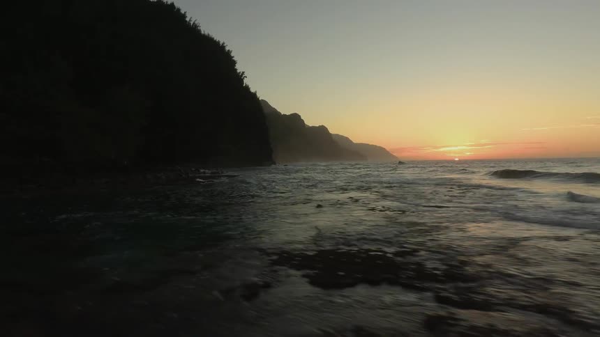 The waves hit the shore at sunset