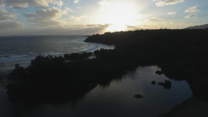 The sun shines as the ocean tide flows to the shore