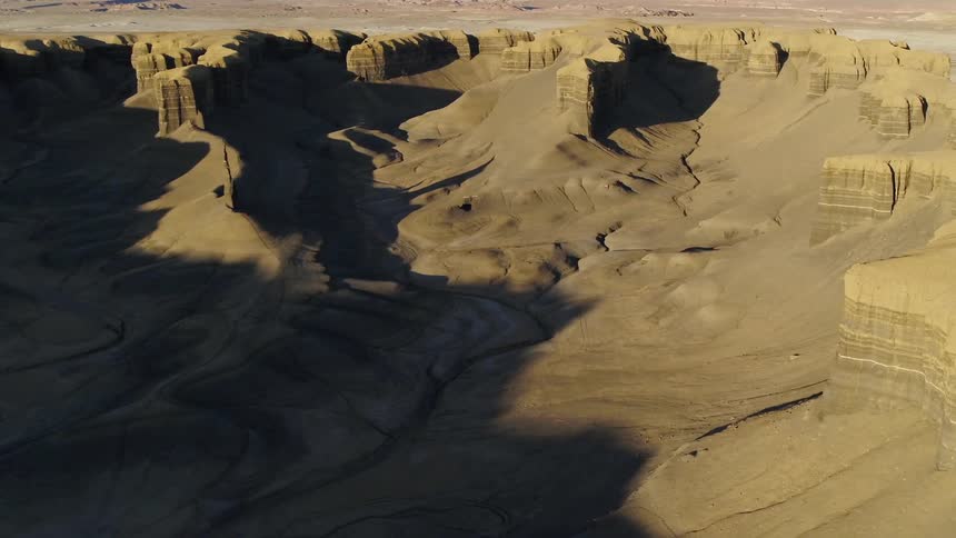 Shadows fall over hilly desert landscape on a sunny day