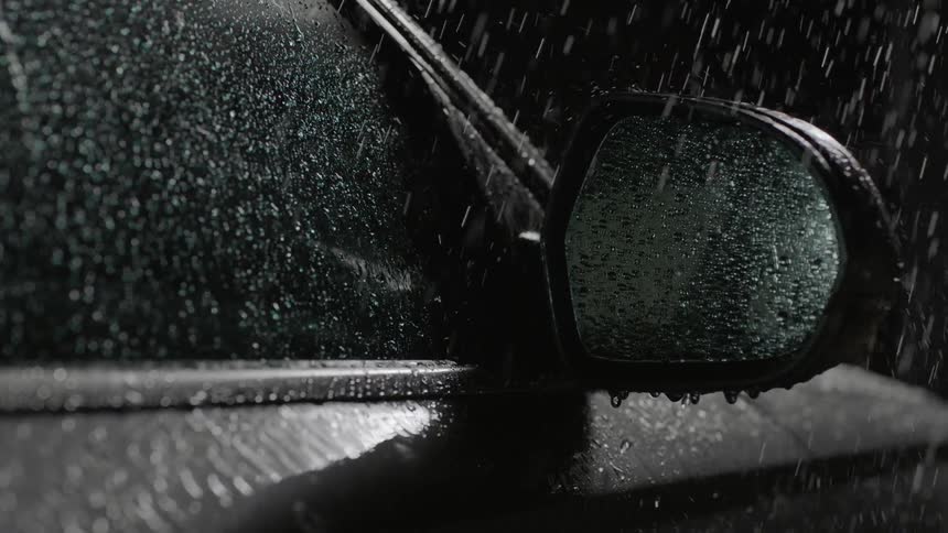 Rain falls on a vehicle in the dark