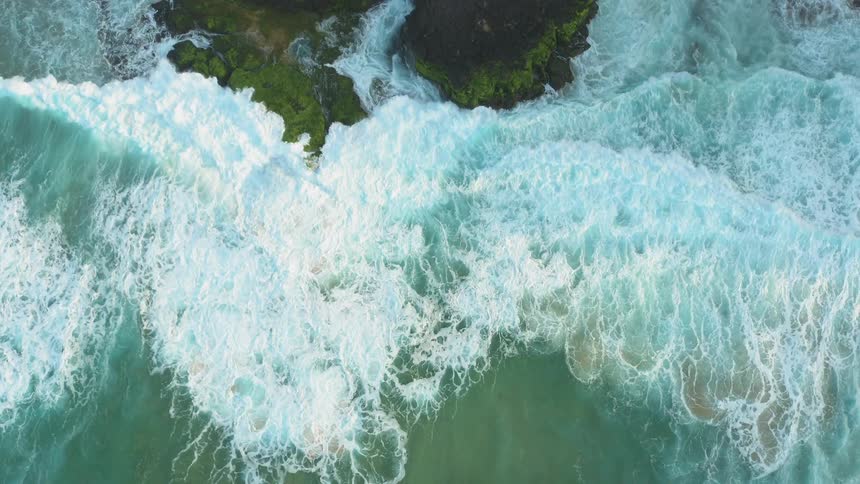 Ocean waves crash into a shoreline