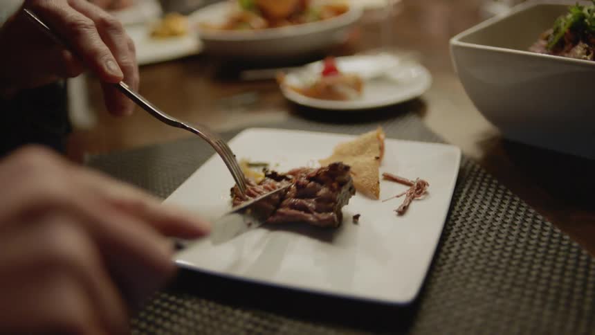 A man cuts meat on the plate