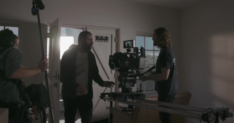 Men and woman walk into a house with recording equipment