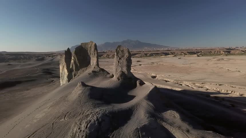 Hilly desert landscape with tall rocks jutting up