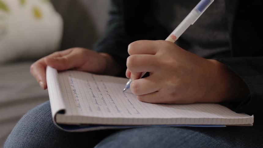 Person writes on a notepad