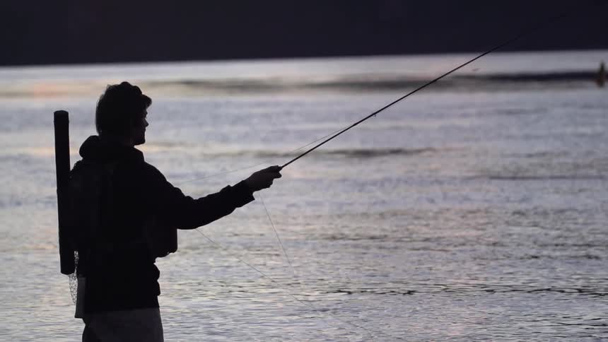 A man fishing as the sun sets