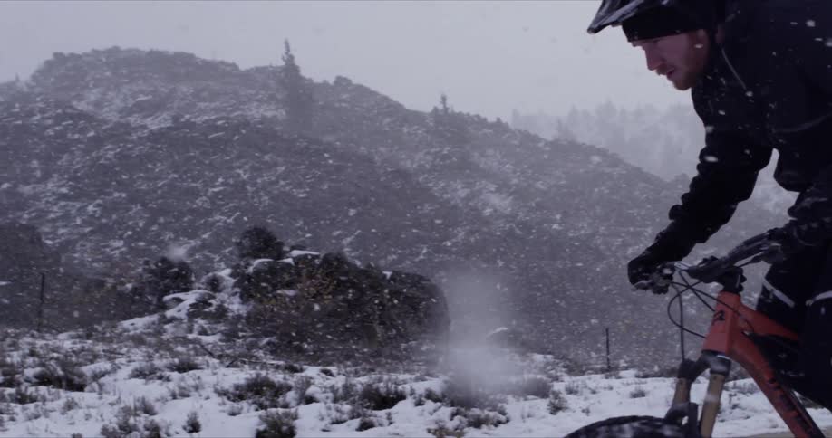 Man riding his bike down a snow path