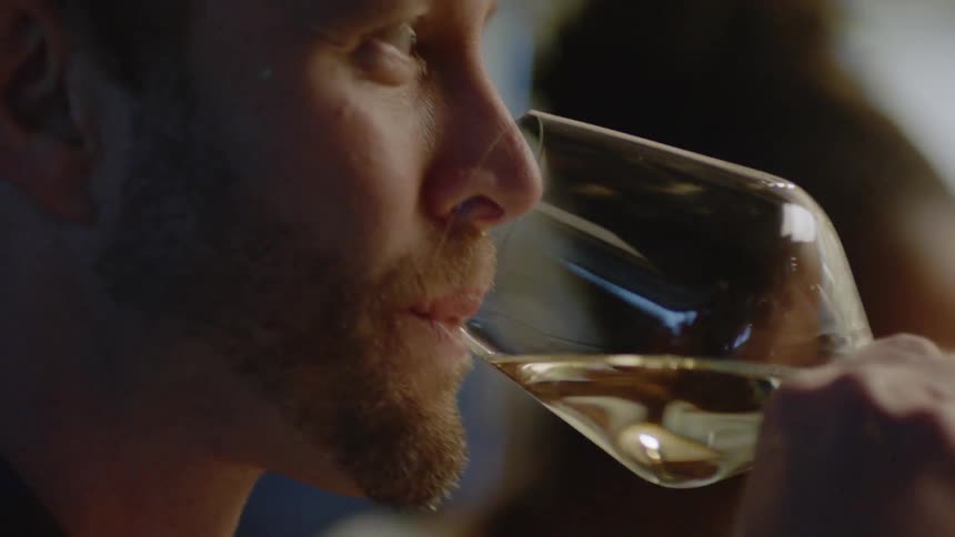 A group of people dine at a restaurant and drink wine