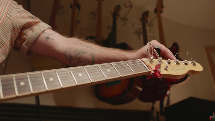 A man tunes a guitar