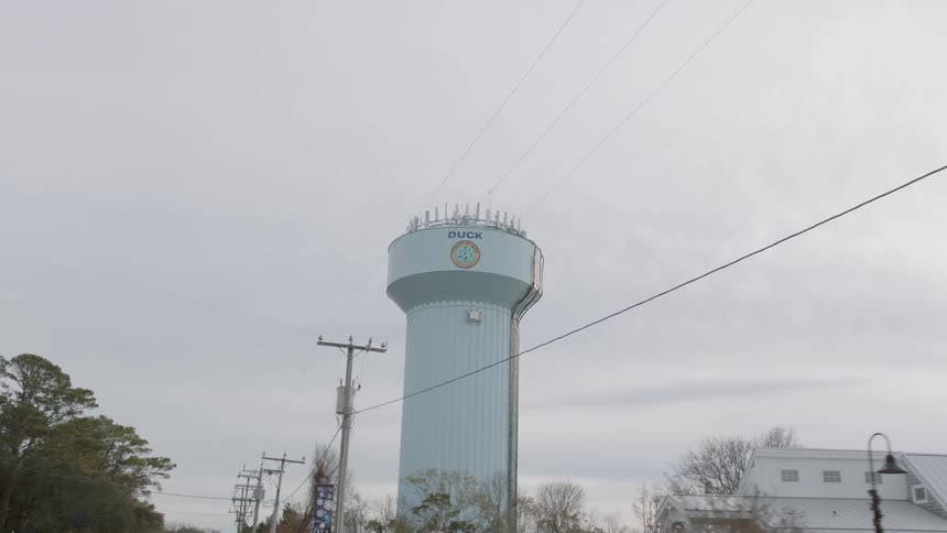A water tower stands tall above the small town buildings