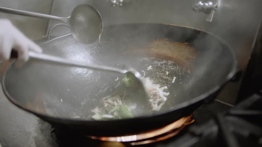 A man cooks in a wok