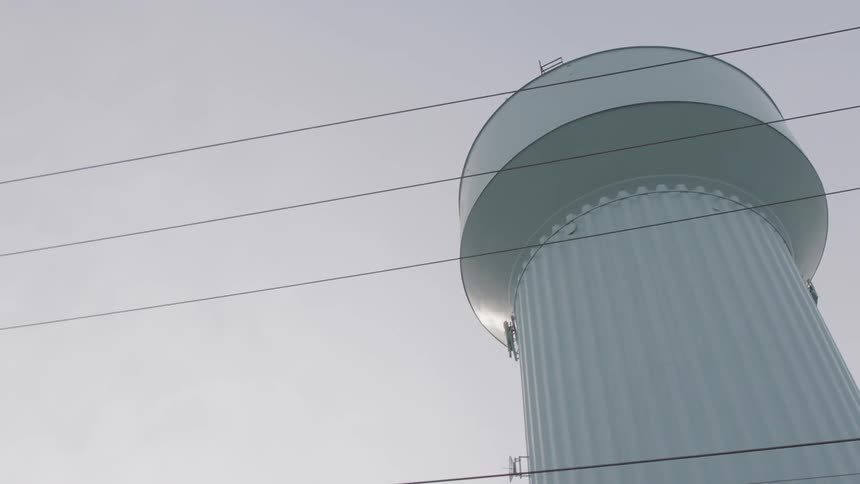 A water tower is next to a road