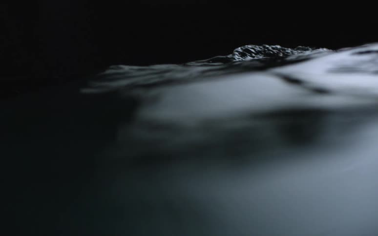 A liquid substance rolls and undulates in abstract