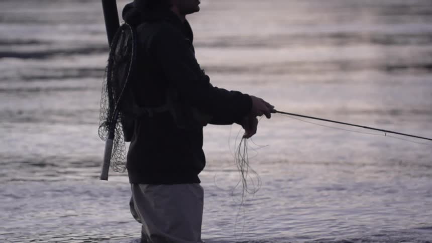 Man is standing in water fishing