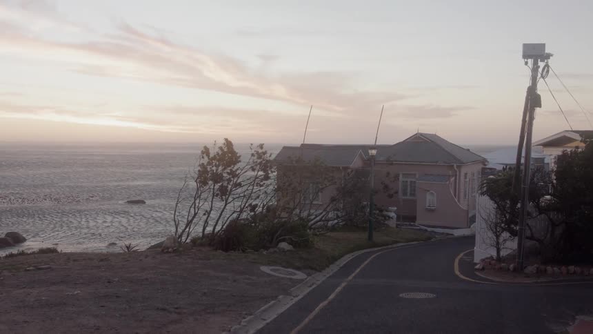 House on the edge of a body of water and a road leading up to it