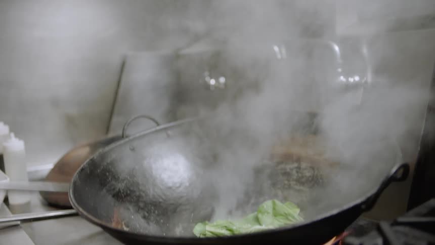A man cooks in a wok