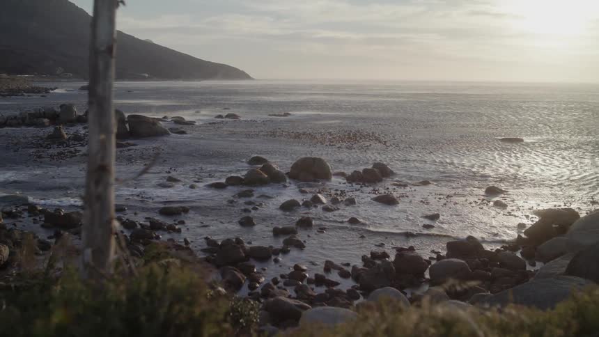 Sun sets over a rocky beach