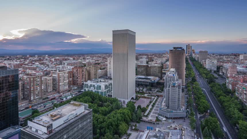 Traffic moves through and past a city at sunset