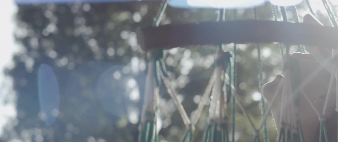Woman spins in a hammock on a sunny day