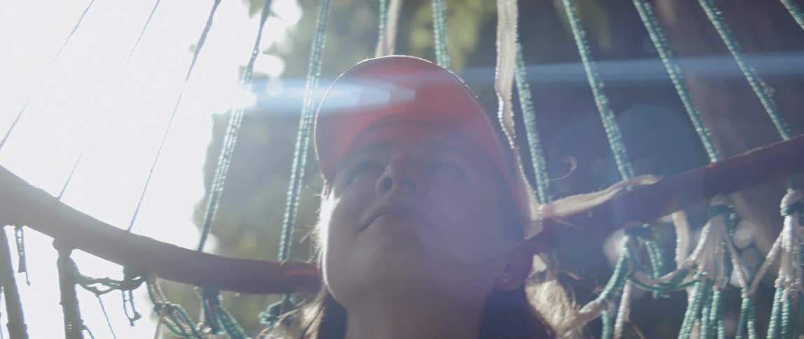 Woman sits on a hammock on a sunny day