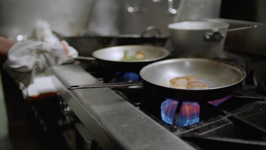 A chef cooks food on a stove