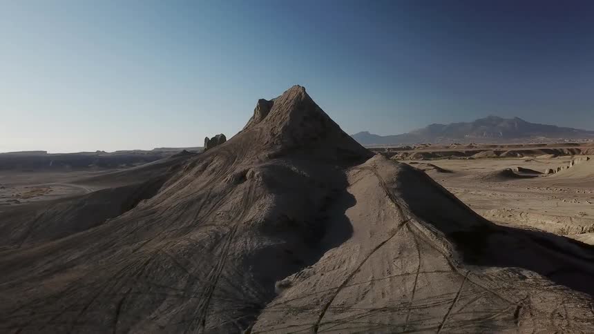 Sun shines over a hilly desert landscape
