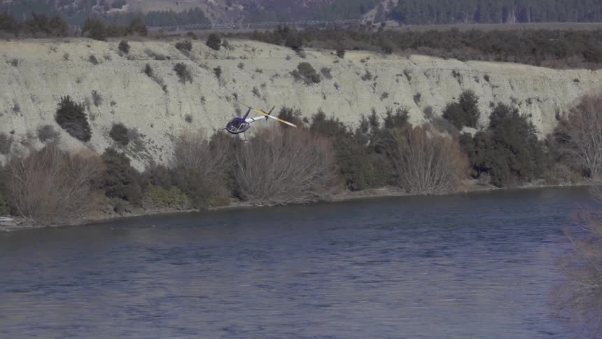 A helicopter flies over a lake