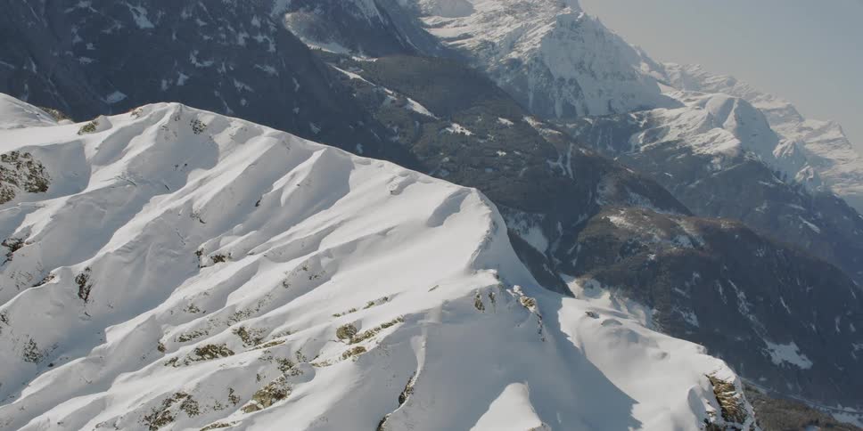 Sun shines on snowy rocky mountains