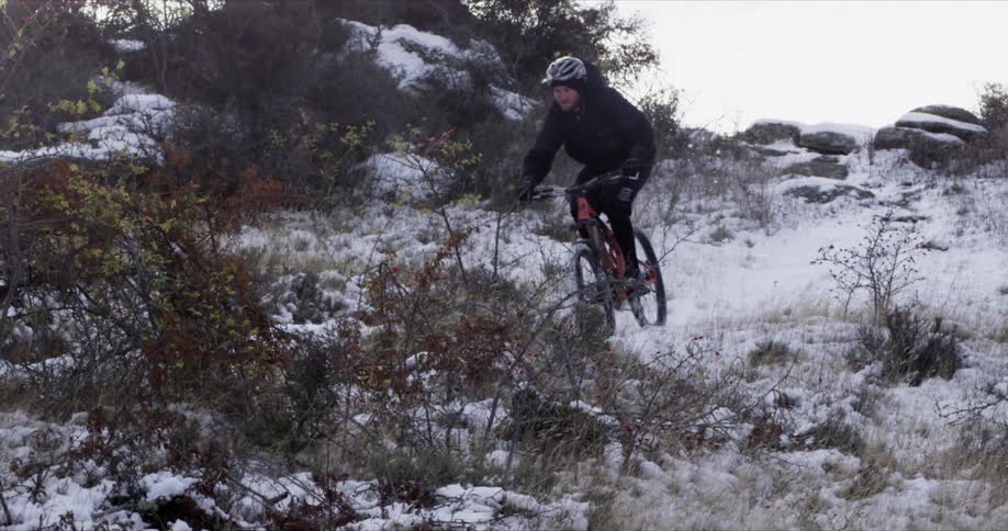 A mountain biker on a snowy hill