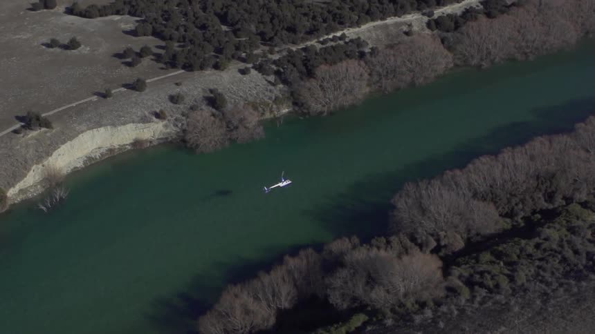 A helicopter flies over a river