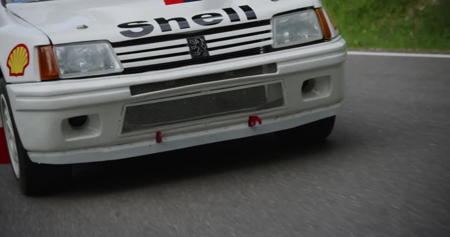 White car with decals on it travels over the highway